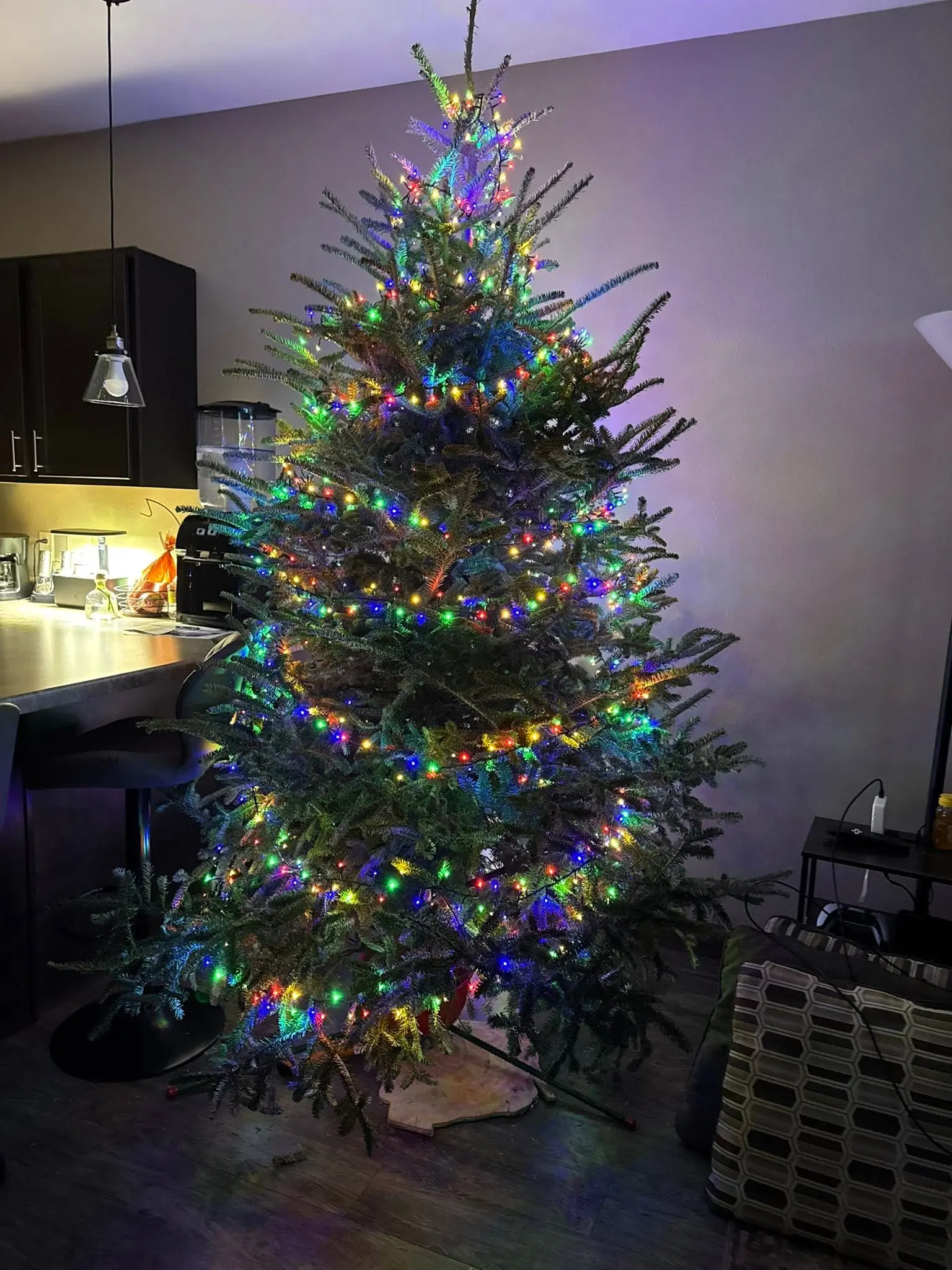 Christmas tree with multicolor lights in a kitchen and living room